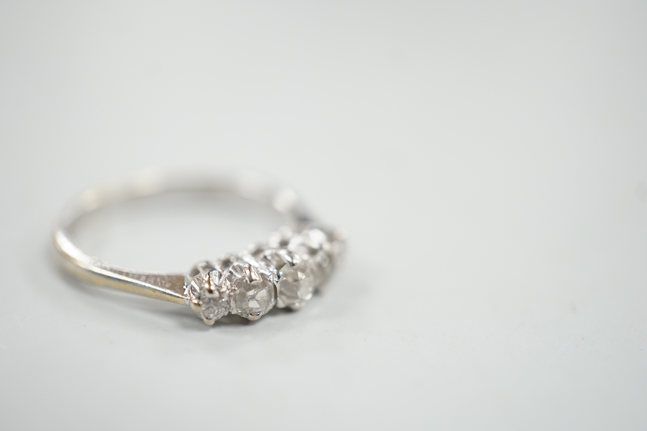 A 1970's 18ct white gold and graduated five stone diamond ring, size L/M, gross weight 3 grams.